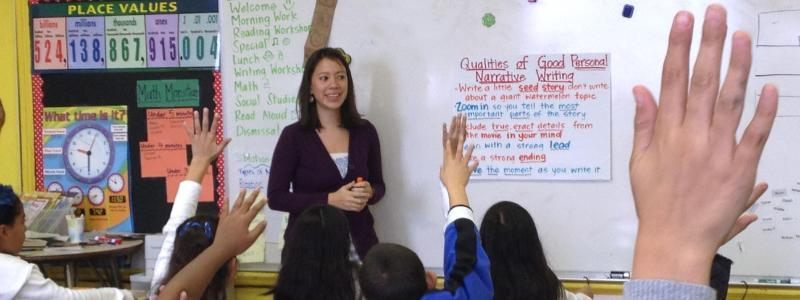 elementary teacher with lots of raised hands