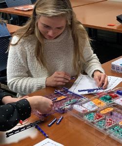 teacher with colorful materials on students desk