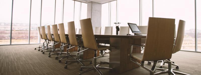 Corporate board room with empty chairs around table