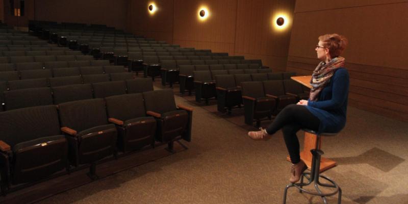 a woman sitting in an auditorium