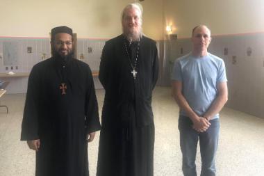 three men standing together and smiling