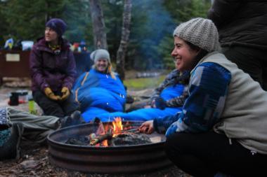 Two girls sitting at campfire