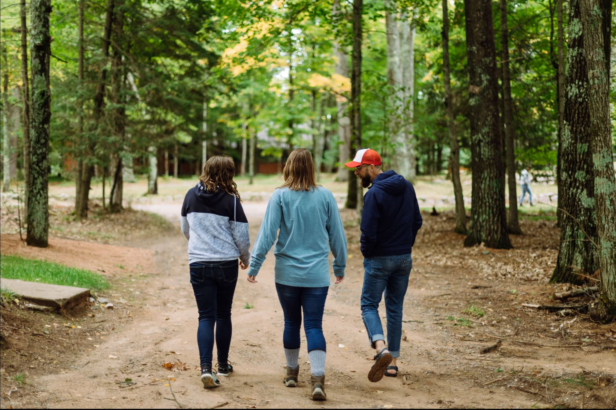 Three people walking in woods