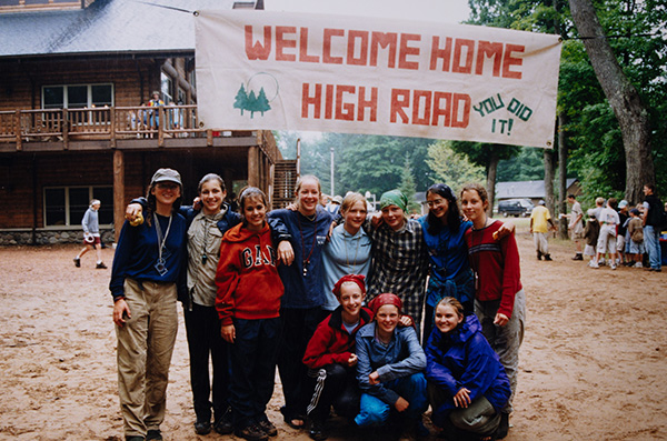 A group of people smiling under a banner reading Welcome Home High Road, You Did It!