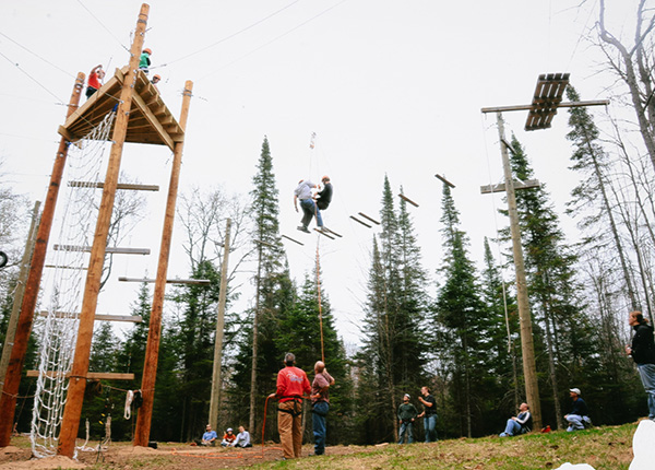 Two people walk on an outdoor ropes course
