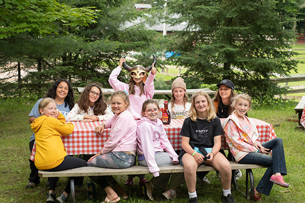 A group of girls sitting by a picnic table