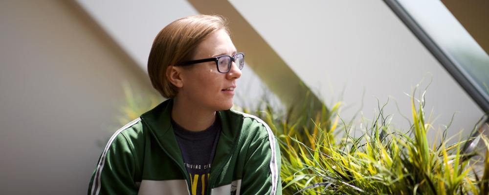 student sitting and looking out a window