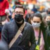 Two People walking in a crowd with masks on