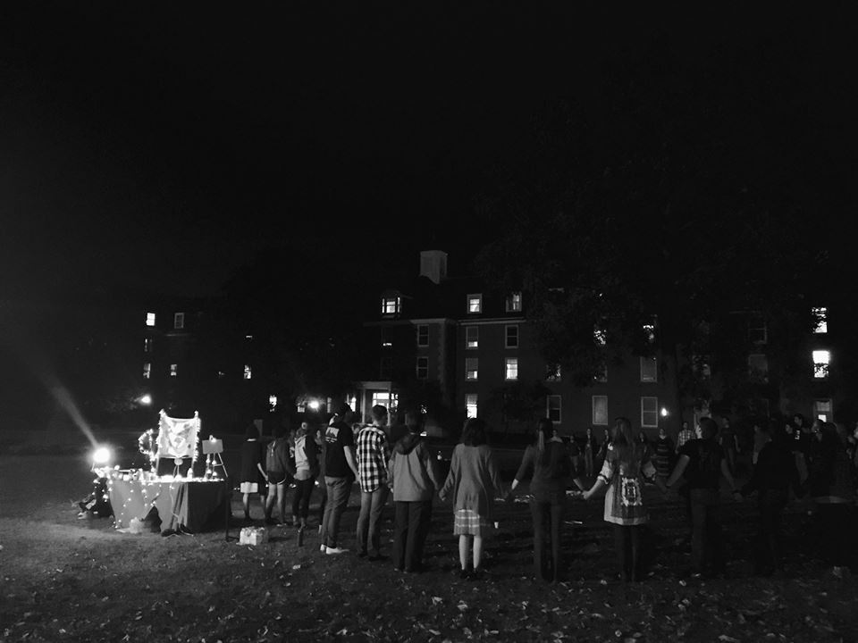 People holding hands praying outside