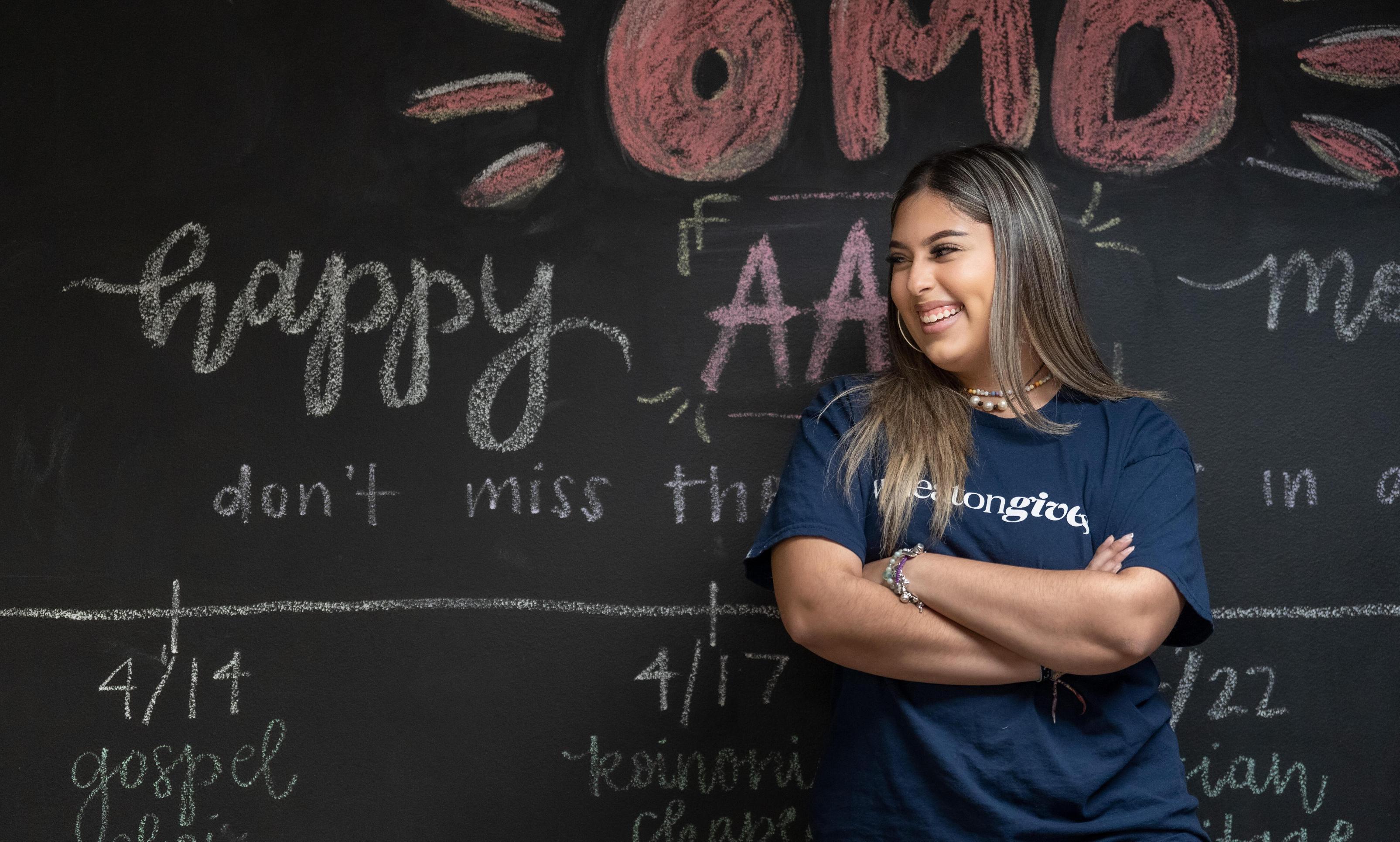 Female Wheaton Student in front of chalk board in OMD