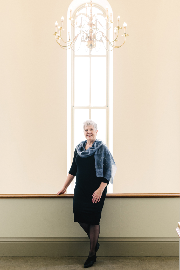 Wheaton College IL Marilee Melvin standing in front of a window