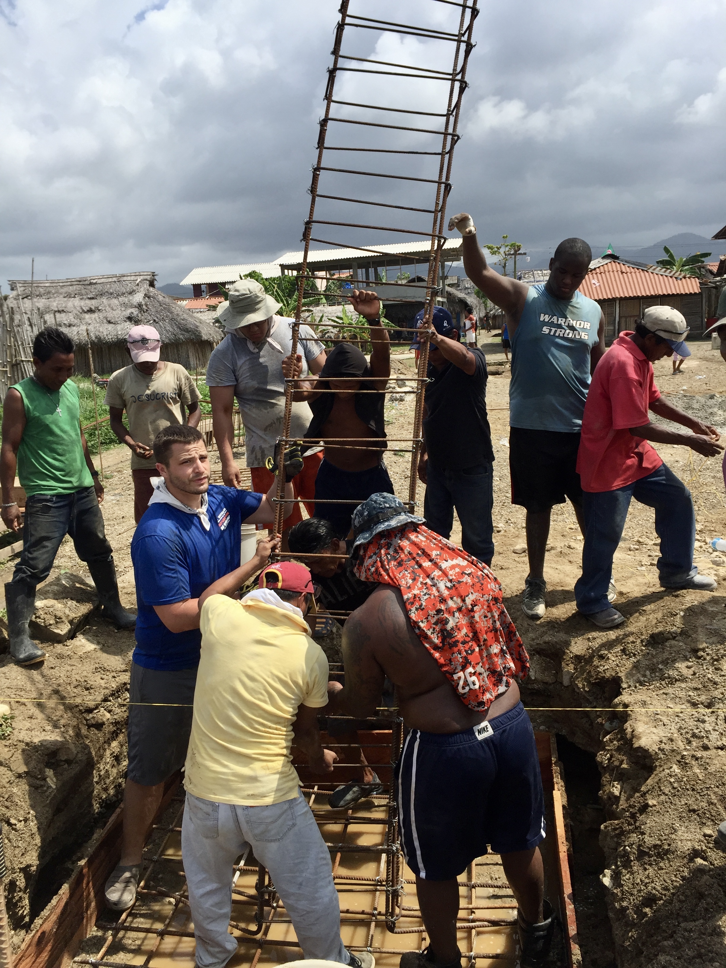 Wheaton head football coach Jesse Scott helping local Kuna men and football players put in rebar for the church they helped rebuild.