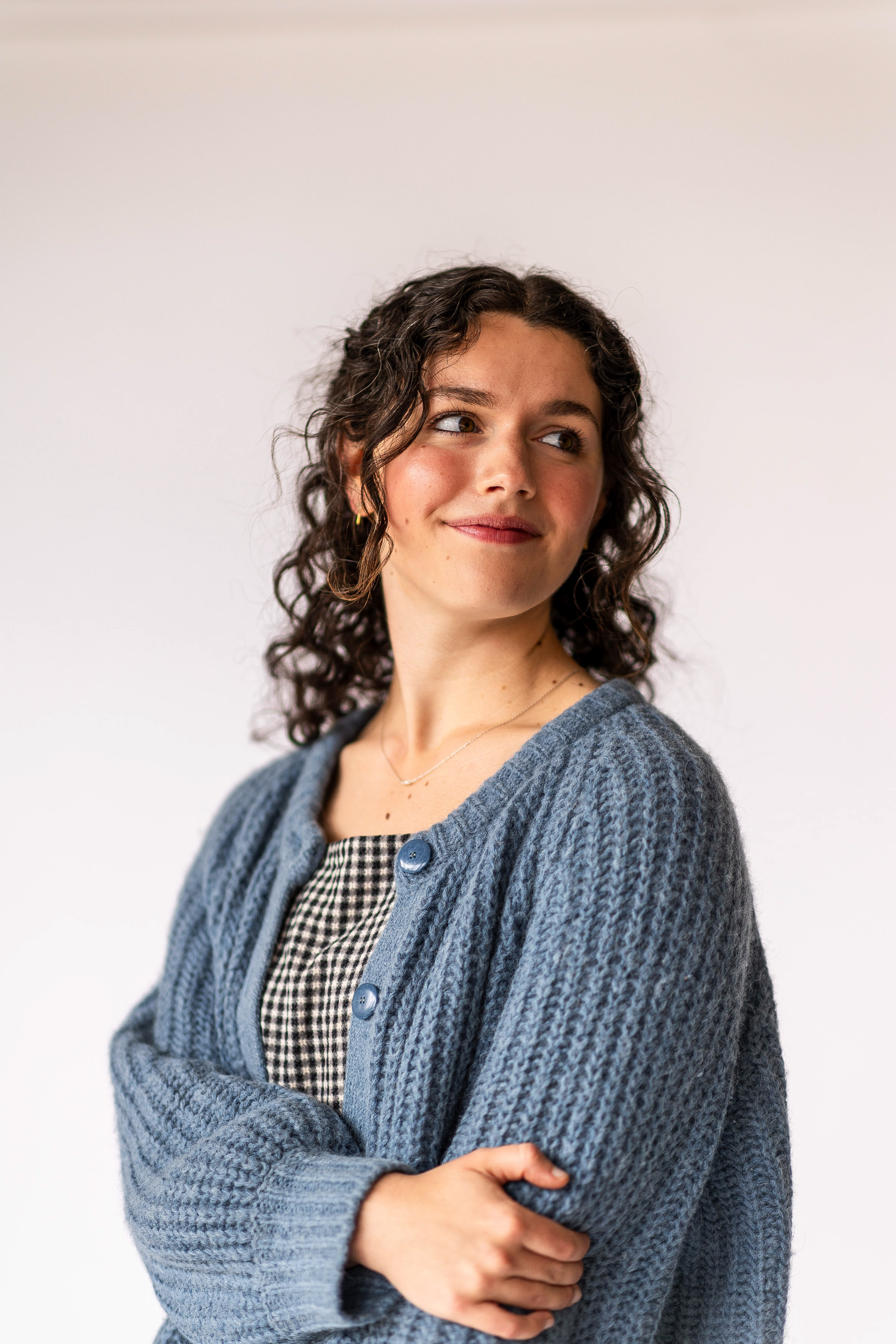 Doctoral student wearing a blue sweater and black and white gingham dress