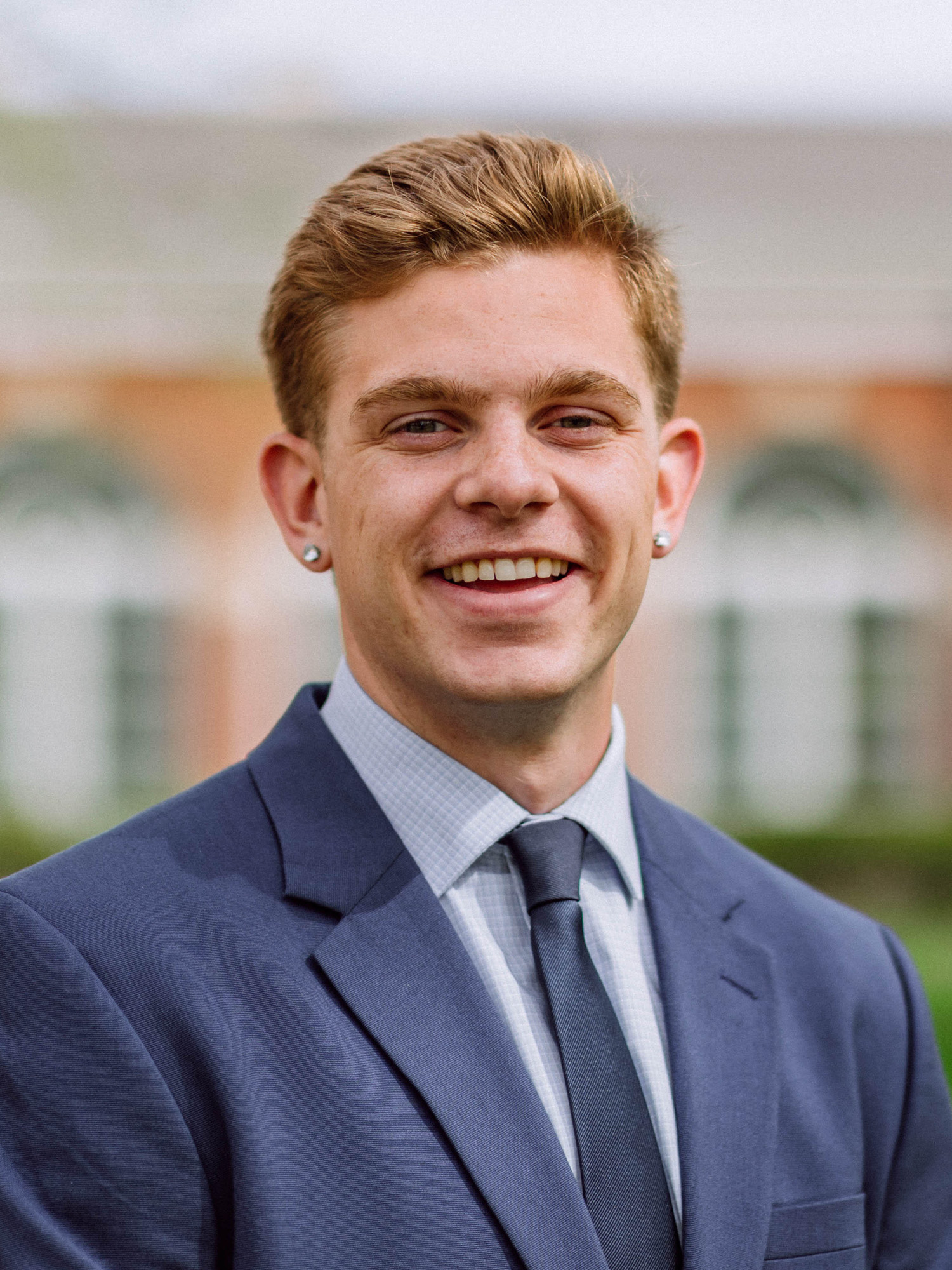 A young white male with blonde hair smiles