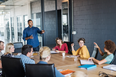 A group of adults sit around a table talking
