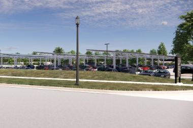 A filled parking lot that contains a structure of solar panels held up by thin columns