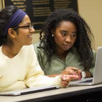 Students writing at a computer